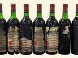 six bottles of red wine are lined up in a row