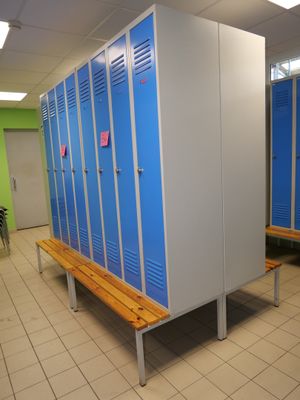 a row of blue lockers in a room with a bench