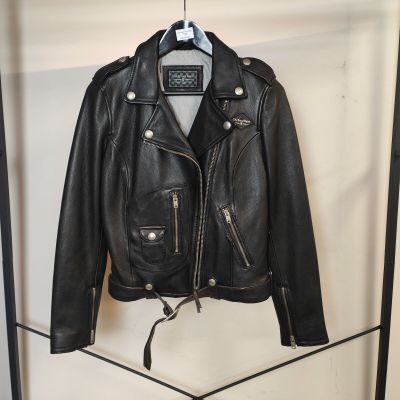 une veste en cuir noir suspendue à un portant dans une pièce