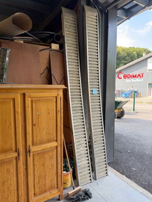 une porte de garage qui a été enfoncée et qui est appuyée contre le mur d'un immeuble