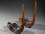 pair of carved wooden shoes with red and black designs on them