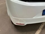 a white car parked in a parking lot with its hood up