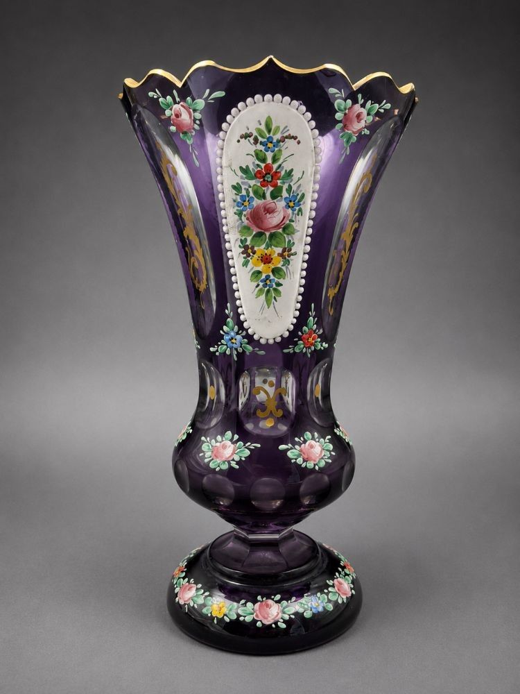 Vase cornet sur pied douche en verre couleur améthyste, à décor émaillé polychrome de bouquets fleuris. Hauteur 18 cm...