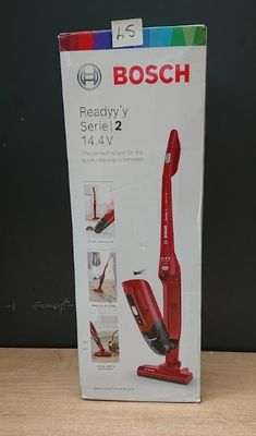 packaging of a red vacuum cleaner sitting on top of a wooden table