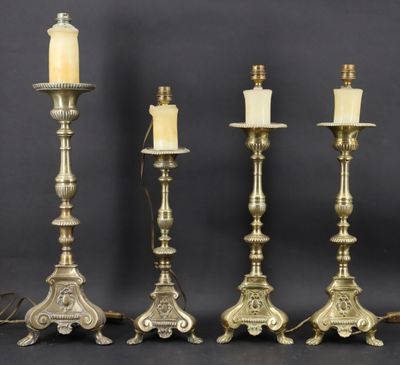un ensemble de quatre bougeoirs en laiton ancien