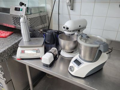 un plan de travail de cuisine sur lequel se trouvent un mixeur, un blender et une balance
