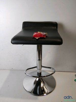 un tabouret de bar noir sur lequel se trouve un morceau de nourriture rouge
