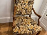 a chair with a floral upholstered seat in a room