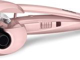 le sèche-cheveux rose est posé sur une surface blanche