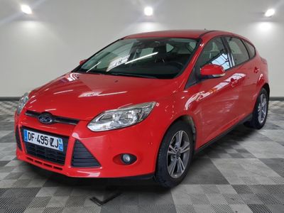 La Ford Focus rouge est garée dans une grande pièce.
