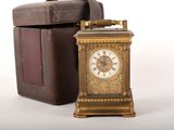 une petite horloge posée à côté d'une boîte