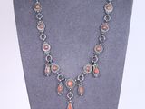 un collier composé de perles de corail et d'argent, présenté sur un mannequin