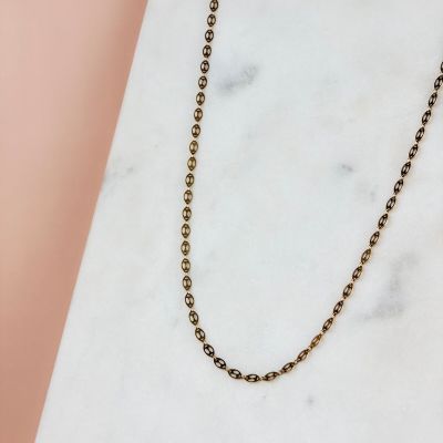 the gold ball chain necklace on a marble surface