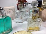 many different perfumes on a table with a gold plate