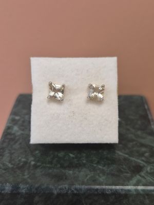 une paire de boucles d'oreilles posée sur un tissu blanc