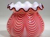 a red and white vase with a wavy design on it