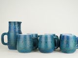 five blue mugs sitting next to each other on a table