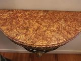a small table with a marble top on a hard wood floor