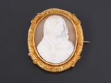 a gold and white cameo of a woman in a veil