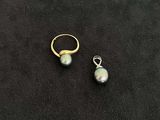 a pair of pearl earrings on a black surface