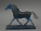 a glass horse that is standing on a base