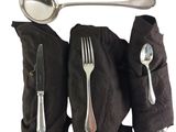 a spoon, fork, and spoon rest on a black cloth