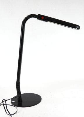 une lampe de bureau noire surmontée d'une ampoule rouge