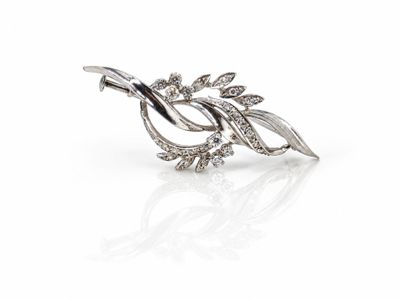un gros plan d'une broche en argent ornée de feuilles