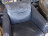 a black leather chair and a black leather recliner in a room