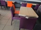 des chaises et des tables violettes et orange dans un restaurant aux murs en briques