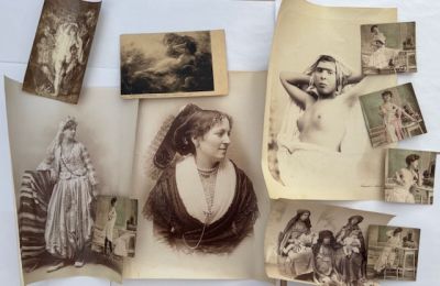 Plusieurs vieilles photos de femmes et d'hommes sont exposées sur une table