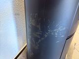 a black trash can sitting on a pallet next to a wall