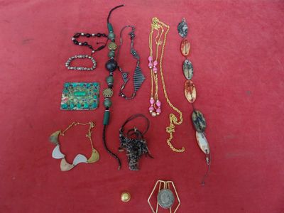 a lot of jewelry that is laying out on a red surface