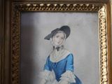une photo d'une femme en robe bleue dans un cadre doré