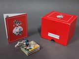 une boîte rouge contenant une petite figurine représentant un homme à cheval