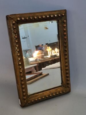 a mirror sitting on a table with candles in the background