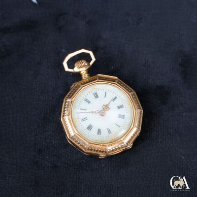 une montre de poche en or avec des chiffres romains