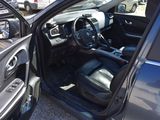the interior of a car with the door open and the driver ' s seat down