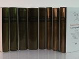 several books are lined up in a row on a white surface