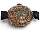 a gold watch with a picture of a bird on it