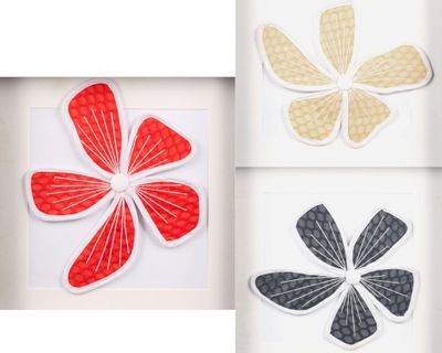 three framed pictures of four different colored paper flowers in a white frame