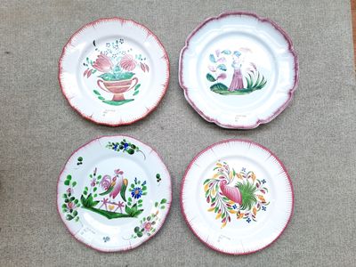 four plates with different designs on them sitting on a table