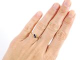 a woman ' s hand with a gold ring on it