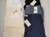 trois paires de pantalons pour homme posées les unes à côté des autres sur une table