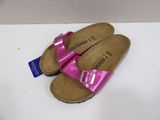 pair of pink sandals with buckles on them sitting on a white surface