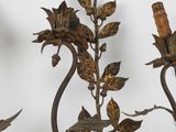a metal candle holder with flowers and leaves on it
