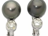 une paire de boucles d'oreilles en perles noires et diamants sur fond blanc