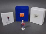 the figurine is next to a box of cards and a card
