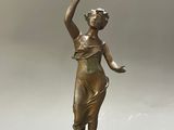 a bronze statue of a woman holding a bird in her hand