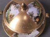 a gold plate with a lid that has a picture on it